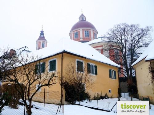 żółty dom ze śniegiem na górze w obiekcie Das Pernerhaus w mieście Pöllau