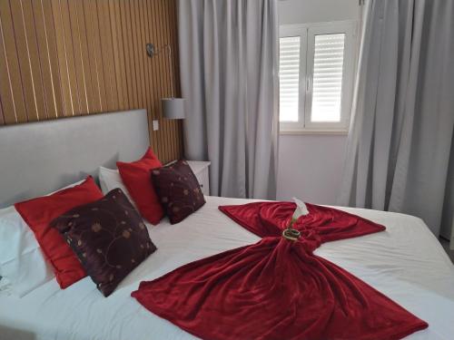 a bedroom with a bed with a red dress on it at Casa da Leninha in Nazaré