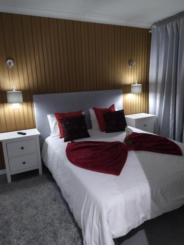 a bedroom with a large white bed with red pillows at Casa da Leninha in Nazaré