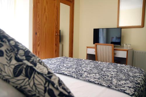 ein Schlafzimmer mit einem Bett mit einer blauen und weißen Decke in der Unterkunft Hotel Playa de Merón in San Vicente de la Barquera