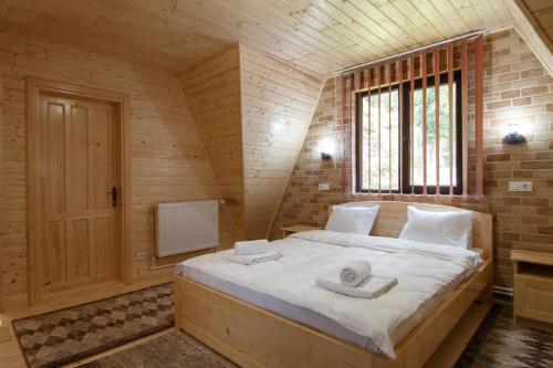 Cette chambre en bois comprend un grand lit. dans l'établissement Centrul de Echitatie Poiana Brasov, à Poiana Brasov