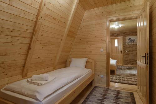 - une chambre avec un lit dans une cabane en bois dans l'établissement Centrul de Echitatie Poiana Brasov, à Poiana Brasov