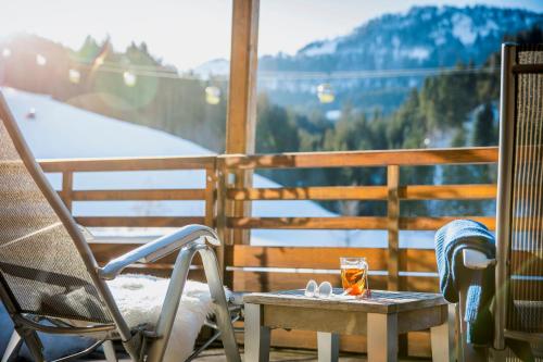 d'une chaise et d'une table sur un balcon avec vue. dans l'établissement TUI BLUE Fieberbrunn, à Fieberbrunn