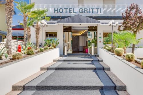 a hotel hallway with palm trees and a hotel building at Hotel Gritti in Lido di Jesolo