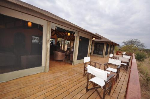 een terras met witte stoelen en tafels in een huis bij Elephant Rock Luxury Camp Tarangire in Kaiti