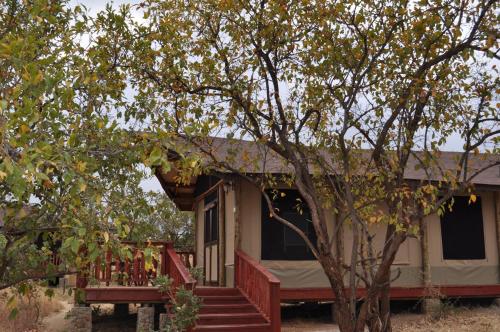 een huis met een veranda en een trap die naar het huis leidt bij Elephant Rock Luxury Camp Tarangire in Kaiti