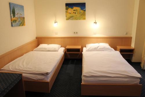 Zimmer mit 2 Betten und 2 Nachttischen in der Unterkunft City Hotel Neuwied in Neuwied