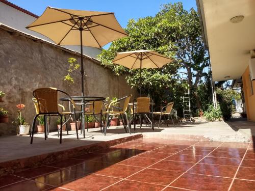 een patio met stoelen, tafels en parasols bij Piezas con Baño Privado Economicas in La Serena