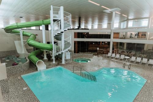 - une grande piscine intérieure avec toboggan dans un bâtiment dans l'établissement Coast Nisku Inn & Conference Centre, à Nisku