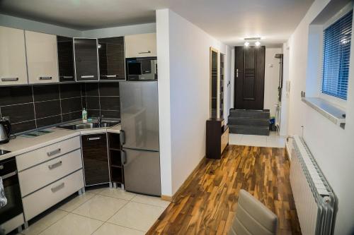 cocina con armarios blancos y suelo de madera en Apartamenty KORONA, en Krosno