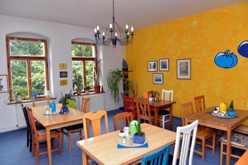 ein Esszimmer mit Holztischen und -stühlen in der Unterkunft Pension Bloo Tomato in Zittau