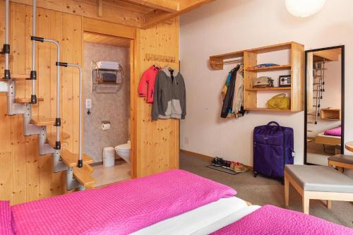 une chambre avec un lit rose et une chambre avec des toilettes dans l'établissement Hotel Alpenblick, à Grindelwald