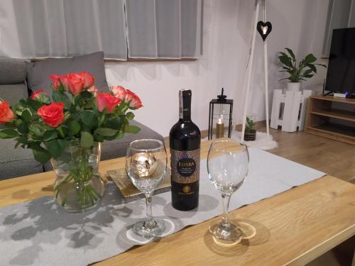 a bottle of wine and two glasses on a table at Apartament KAOLA in Jelenia Góra