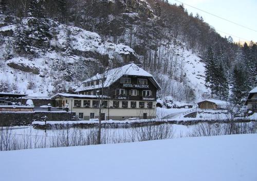 duży budynek pokryty śniegiem przed górą w obiekcie Hotel Waldeck in Todtnau w mieście Todtnau