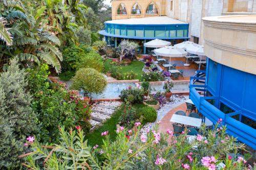 - une vue sur le jardin avec des tables et des parasols dans l'établissement Merit Lefkosa Hotel & Casino, à Lefkosa Turk