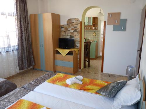 a bedroom with a bed and a tv in a room at Guest House Zhelevi in Sozopol