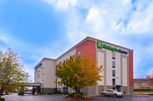 un bâtiment avec une voiture garée sur un parking dans l'établissement Holiday Inn Express & Suites Fayetteville University of Arkansas Area, an IHG Hotel, à Fayetteville