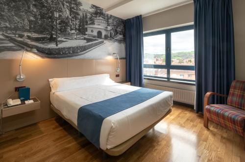 une chambre d'hôtel avec un lit et une fenêtre dans l'établissement Aparthotel Campus, à Oviedo