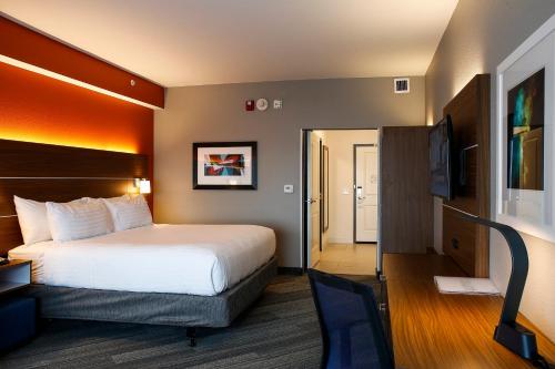 ein Hotelzimmer mit einem Bett und einem TV in der Unterkunft Holiday Inn Express & Suites Downtown Louisville by IHG in Louisville