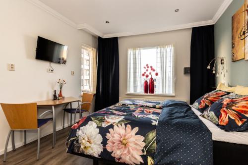 a bedroom with a bed and a desk and a window at SEA MORE in Zandvoort