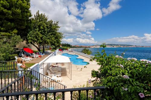 un complejo con una piscina junto al agua en Hotel Val All Inclusive, en Trogir