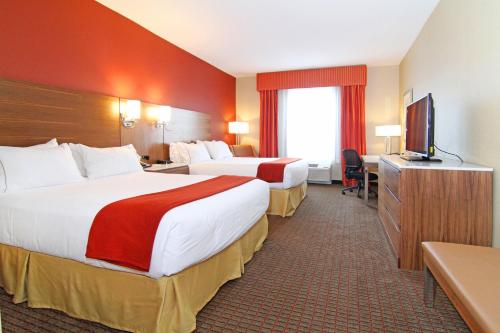 a hotel room with two beds and a flat screen tv at Holiday Inn Express and Suites Calgary University, an IHG Hotel in Calgary