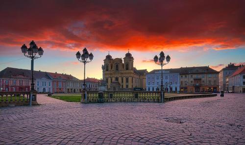 duży budynek w mieście z zachodem słońca w obiekcie 5 Comfortable apartment near old town center w mieście Timişoara