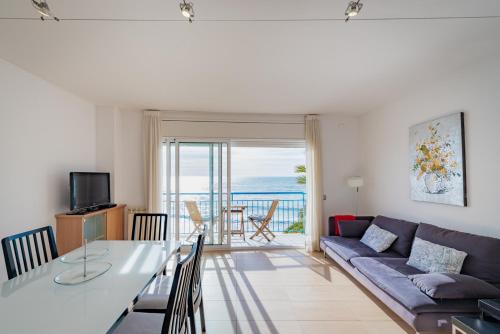 a living room with a couch and a table at InSitges Sant Sebastia's Beach in Sitges