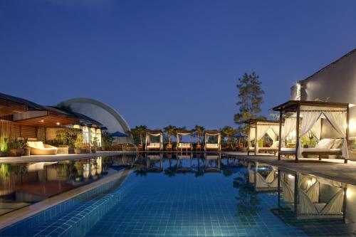 una piscina con sillas y un edificio en Aryaduta Bandung, en Bandung