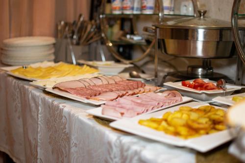 a table with different types of meats and french fries at Hotel Esprit in Braşov