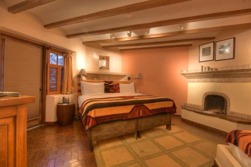 1 dormitorio con 1 cama y chimenea en Inn at Vanessie, en Santa Fe