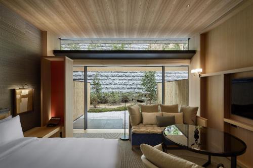 una camera con un letto, un divano e un tavolo in vetro di Park Hyatt Kyoto a Kyoto