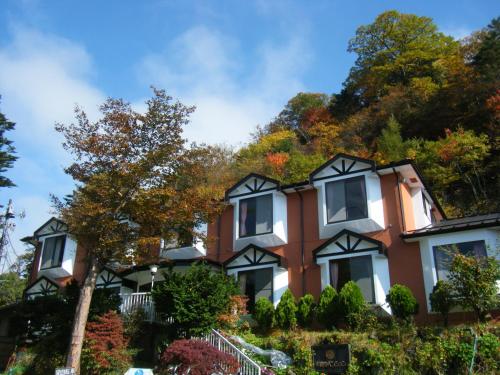 uma casa numa colina com árvores em Chuzenji Pension em Nikko