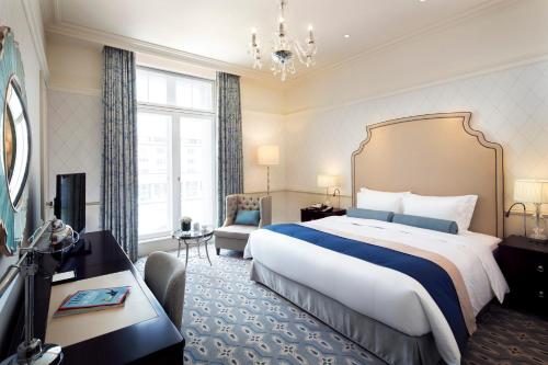 a hotel room with a large bed and a chair at The Tokyo Station Hotel in Tokyo