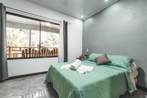 a bedroom with a bed with towels on it at Hotel Hoja de Oro Corcovado in Puerto Jiménez