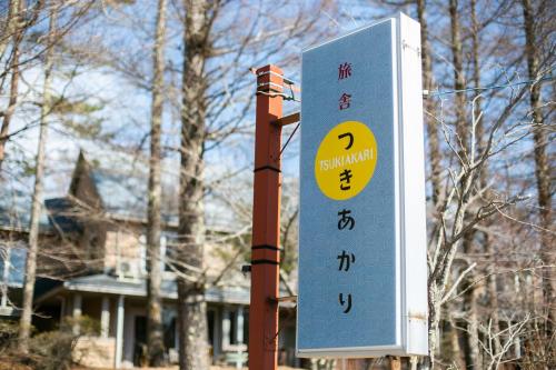 ein Schild an einer Stange vor einem Haus in der Unterkunft Ryosha Tsukiakari in Yamanakako