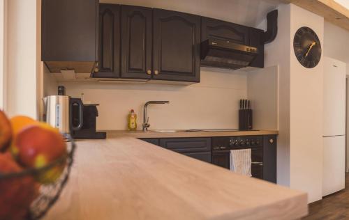 a kitchen with black cabinets and an apple on the counter at Apartment NinetyFour in Annaberg im Lammertal