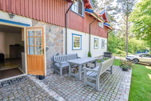 a patio with two benches and a table in front of a building at Apartamentai Geliu Vila in Nida