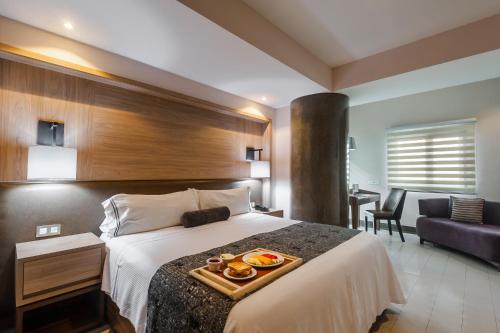 een hotelkamer met een bed en een dienblad met eten erop bij Hotel Real Maestranza in Guadalajara