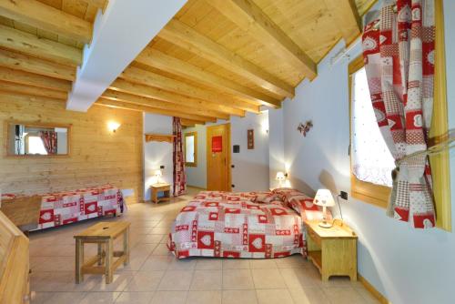 a bedroom in a log cabin with a bed and a table at Hotel L'espoir in Champoluc