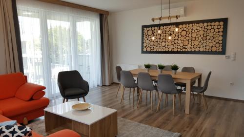 uma sala de estar com uma mesa de jantar e cadeiras em Lelle Resort B26 em Balatonlelle