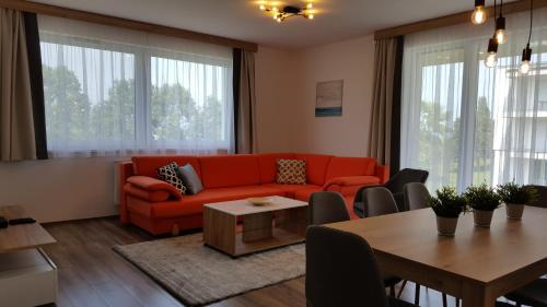 uma sala de estar com um sofá vermelho e uma mesa em Lelle Resort B26 em Balatonlelle