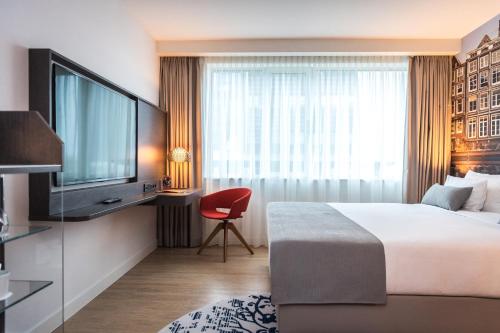 une chambre d'hôtel avec un lit et une télévision dans l'établissement Steigenberger Airport Hotel Amsterdam, à Schiphol