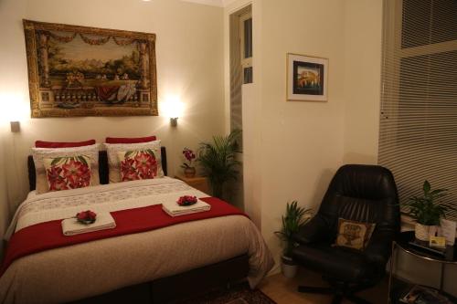 a bedroom with a bed and a black chair at Antonius Bed and Breakfast in Arnhem