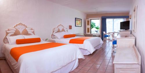 a hotel room with two beds and a television at Flamingo Vallarta Hotel & Marina in Puerto Vallarta