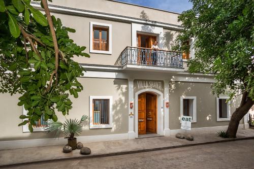 um edifício com uma varanda e uma pessoa numa varanda em Villa Shanti - Heritage Hotel for Foodies em Pondicherry