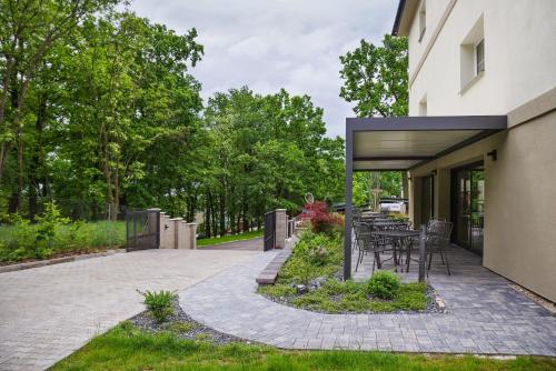 een patio met een tafel en stoelen naast een gebouw bij Penzion Lesni in Milovice