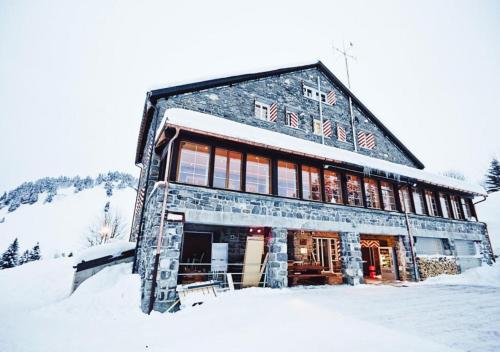 ein großes Gebäude im Schnee mit Schnee in der Unterkunft Maison de Montagne de Bretaye accès par le train arrêt Bouquetin in Villars-sur-Ollon