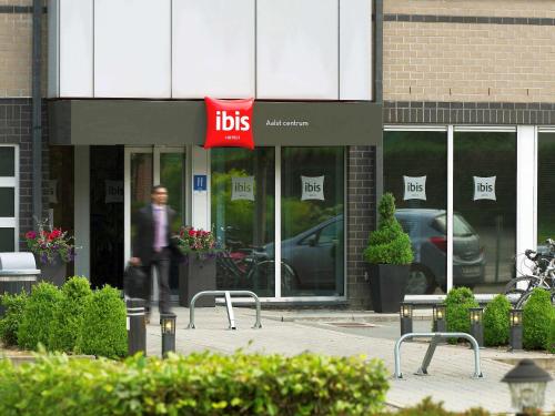 Un uomo che cammina davanti a un negozio di alimentari di ibis Aalst a Aalst