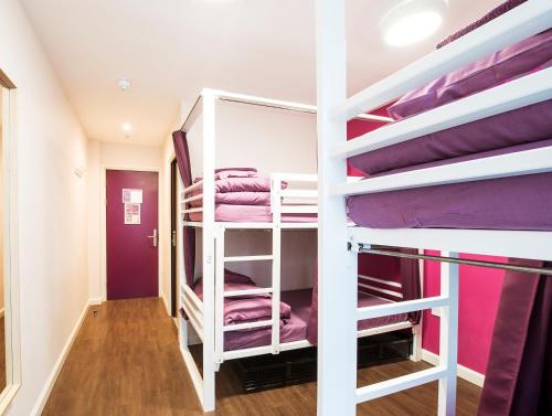 Cette chambre comprend 2 lits superposés avec des draps violets. dans l'établissement Safestay London Elephant & Castle, à Londres